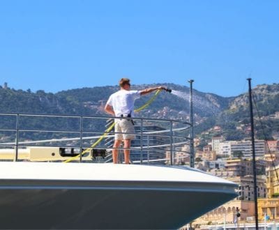 Deck crew washing a motor yacht