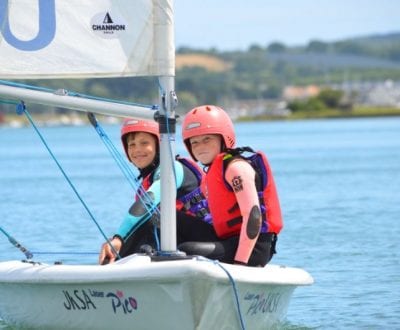 Two students sat on the side of a dinghy