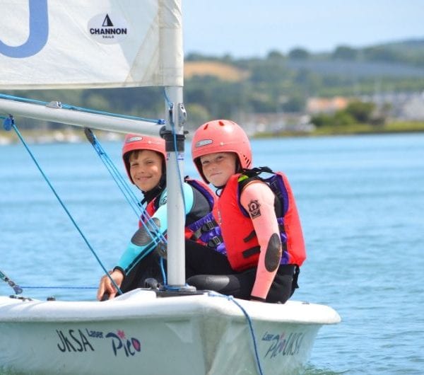 Two students sat on the side of a dinghy