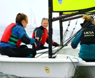 Students learning how to dinghy sail with an instructor