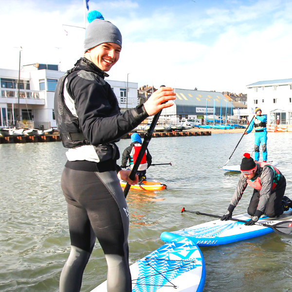 An instructor on a paddleboard smiling