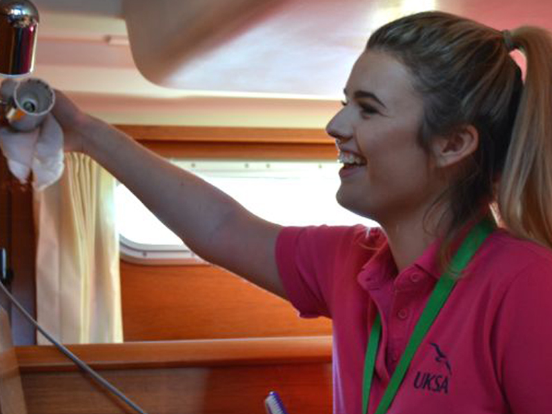 Sarah Bulman cleaning a yacht in Lymington for the Superyacht Interior Course