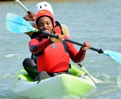 school children paddling on a kayak