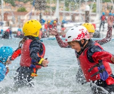 children wearing life jacket splashing in water