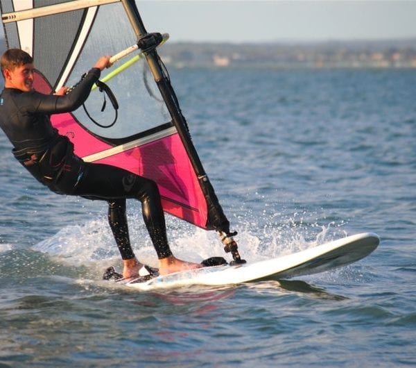 A young man windsurfing on the Solent waters