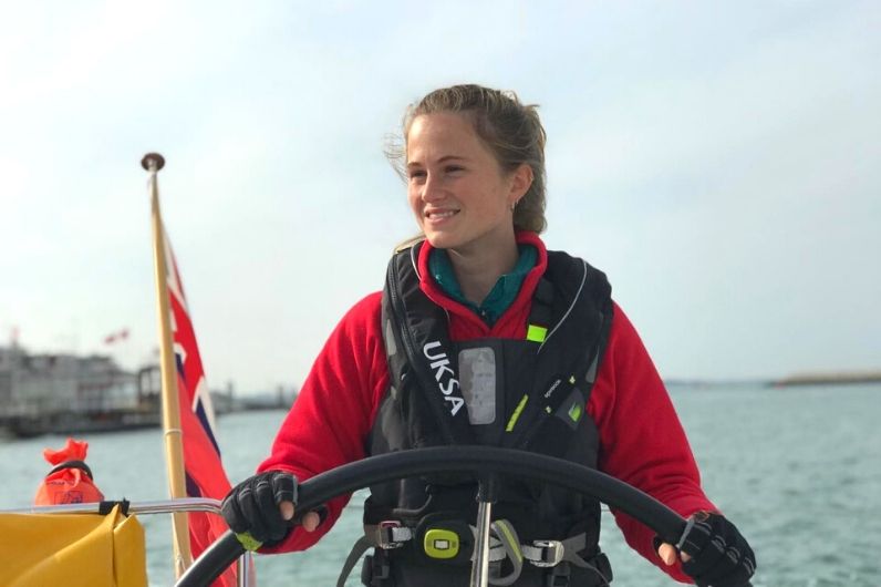 Pip Grundy smiling whilst navigating a yacht