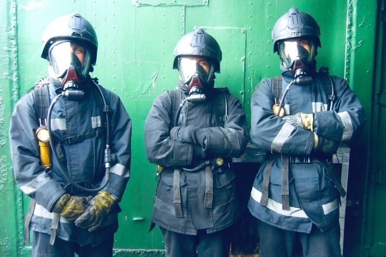 three students wearing fire fighting equipment