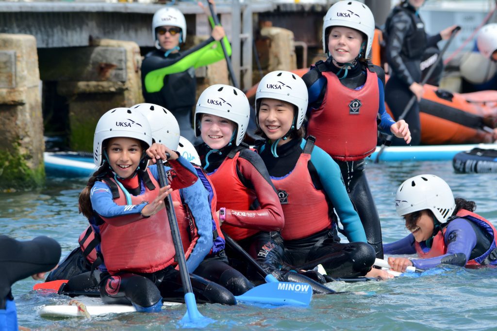 Group of school children wearing wetsuits at UKSA