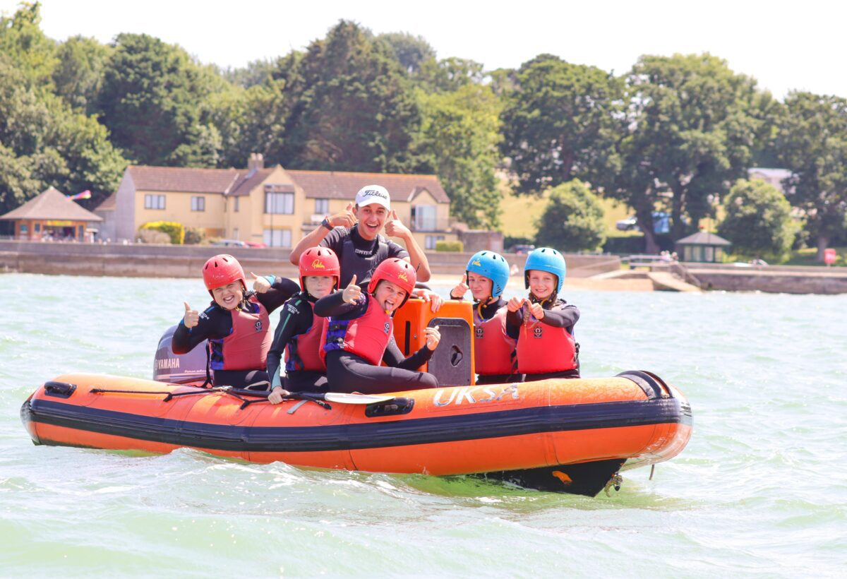 UKSA instructor with group of children on a power boat