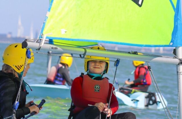 kids sailing a dinghy boat