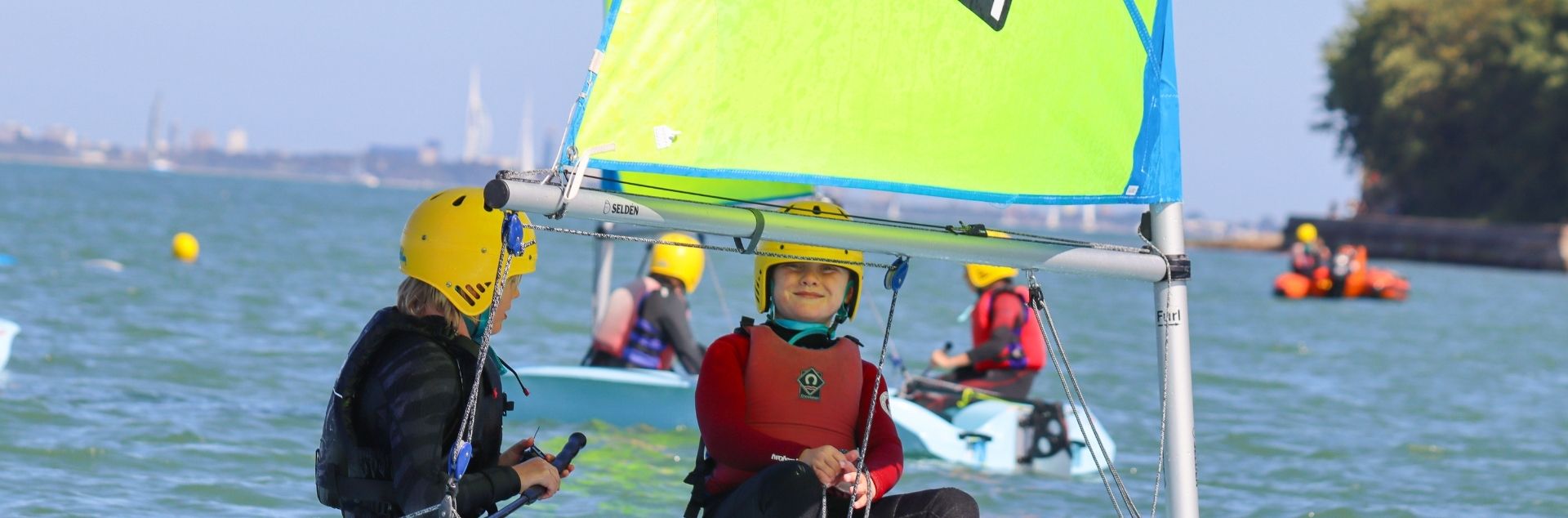 kids sailing a dinghy boat
